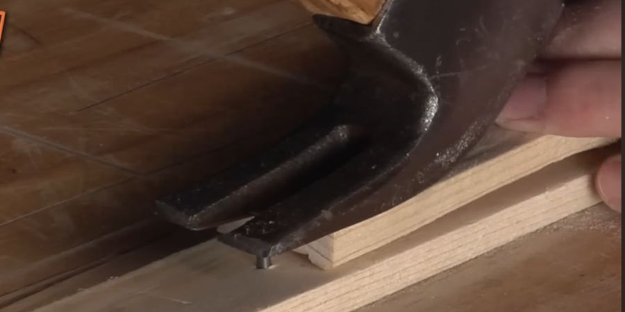 Remove bent nail from wood using claw hammer 